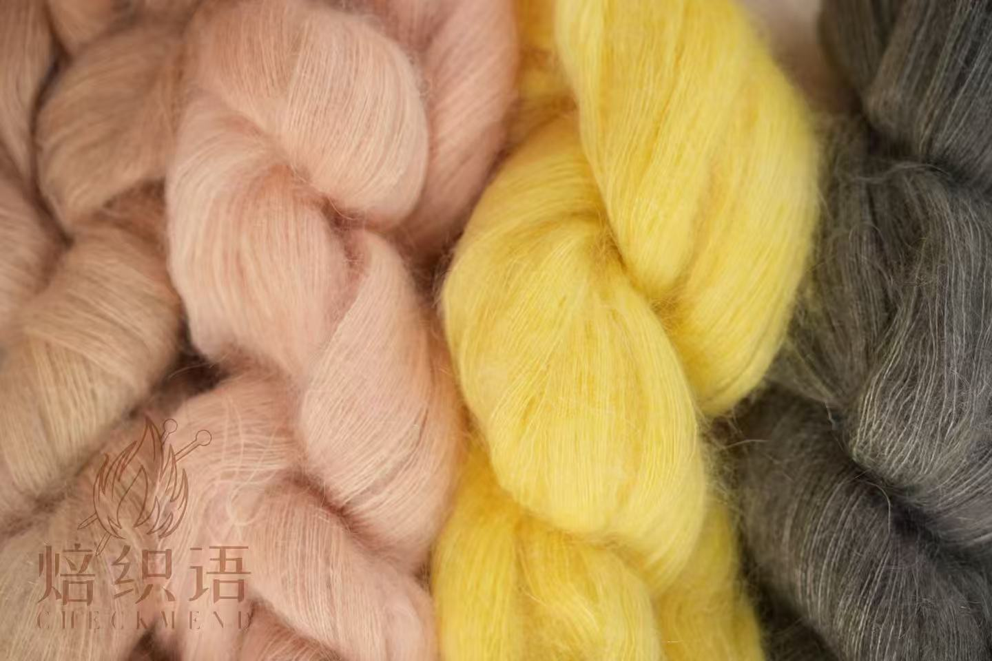 Soft pink, yellow and grey herbal-dyed yarn carrying the CheckMend mark